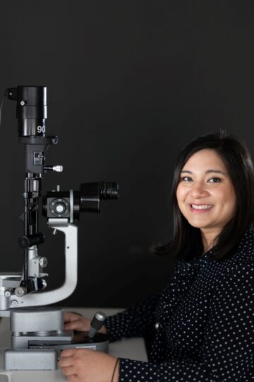 Selina Tomlinson of Bath clinic sitting in front of medical eye equipment